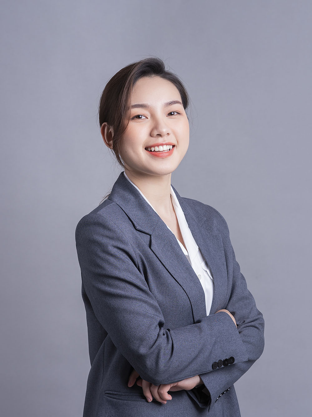 Portrait of a beautiful Asian businesswoman on a gray background